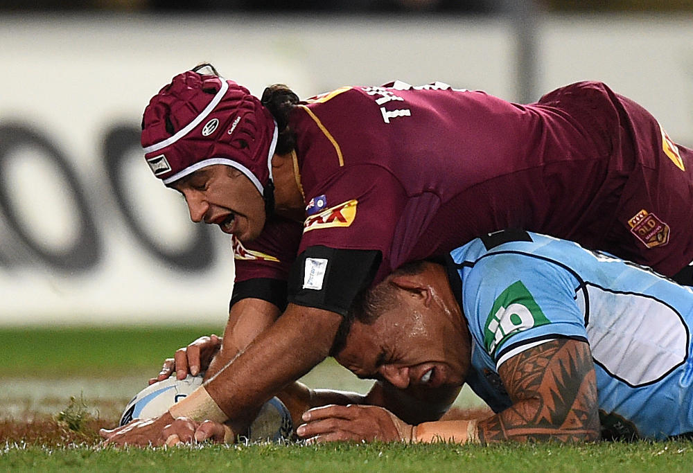 Tyson Frizell of the Blues is tackled by Johnathan Thurston of the Maroons