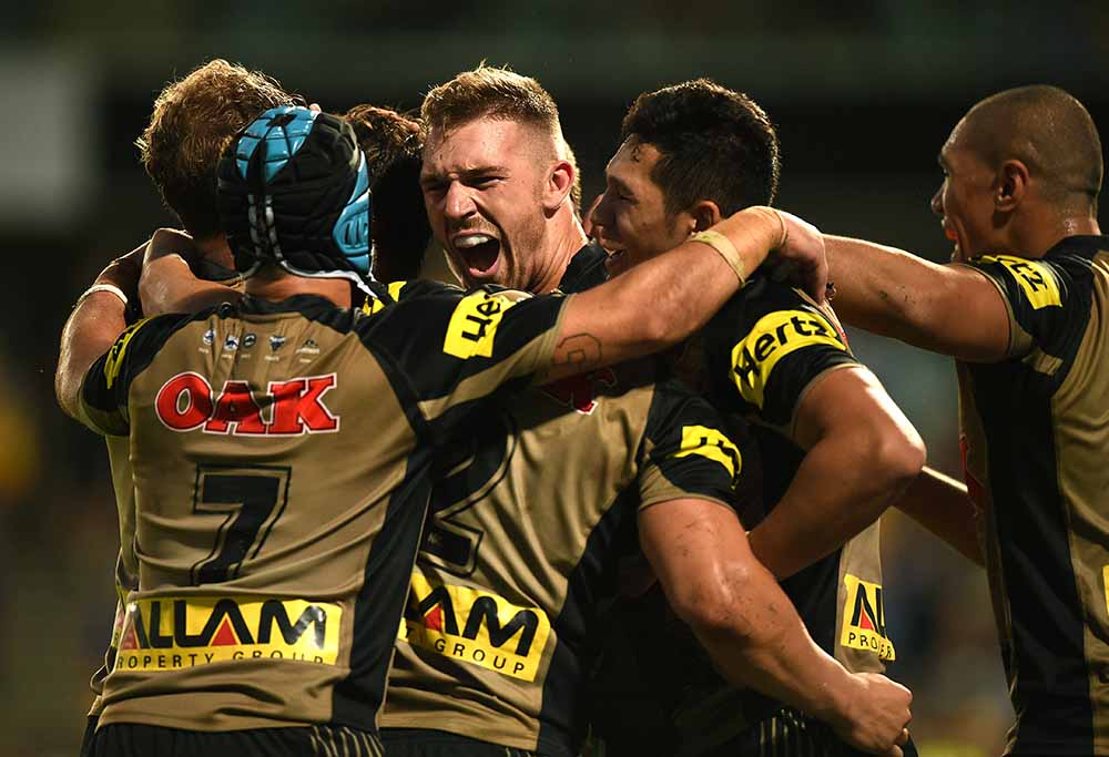 Bryce Cartwright of the Panthers, (centre), celebrates with team mates