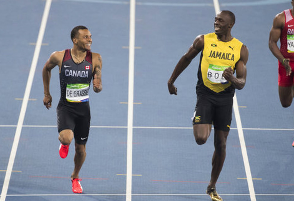 Usain Bolt and Andre de Grasse share a lighter moment as they cross the line during the 100m semi-final at the Rio Olympics