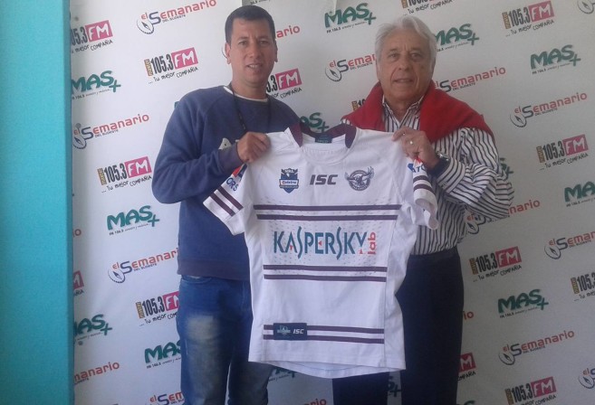 Carlos Varela (right) presenting a Manly jersey to a local radio station in Argentina as part of promoting the sport