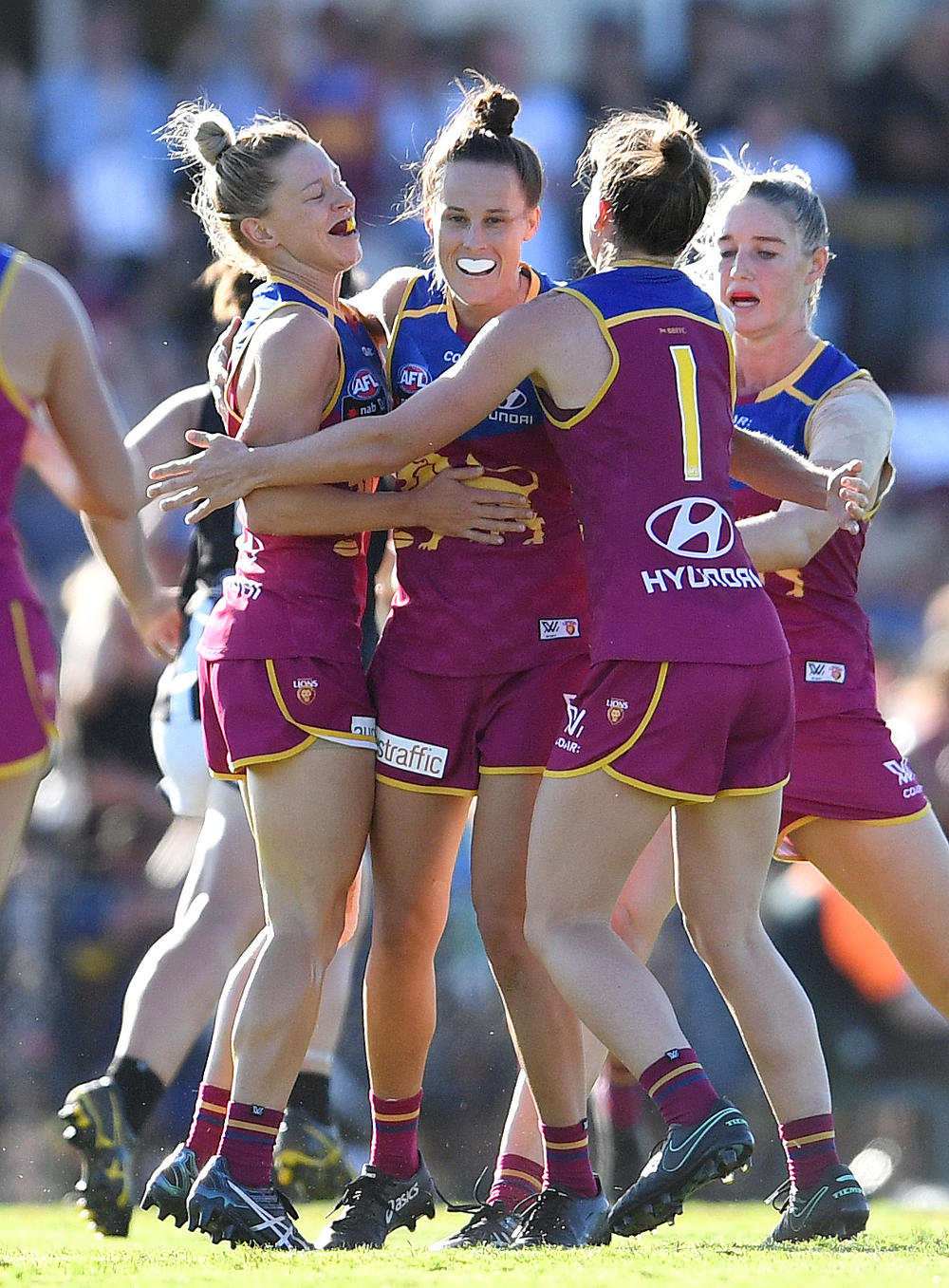 Emma Zeilke of the Brisbane Lions (centre) celebrates scoring a goal during their Round 3 AFLW game against Collingwod at the Southpine Sports Complex in Brisbane, Saturday, Feb. 18, 2017. (AAP Image/Dan Peled)