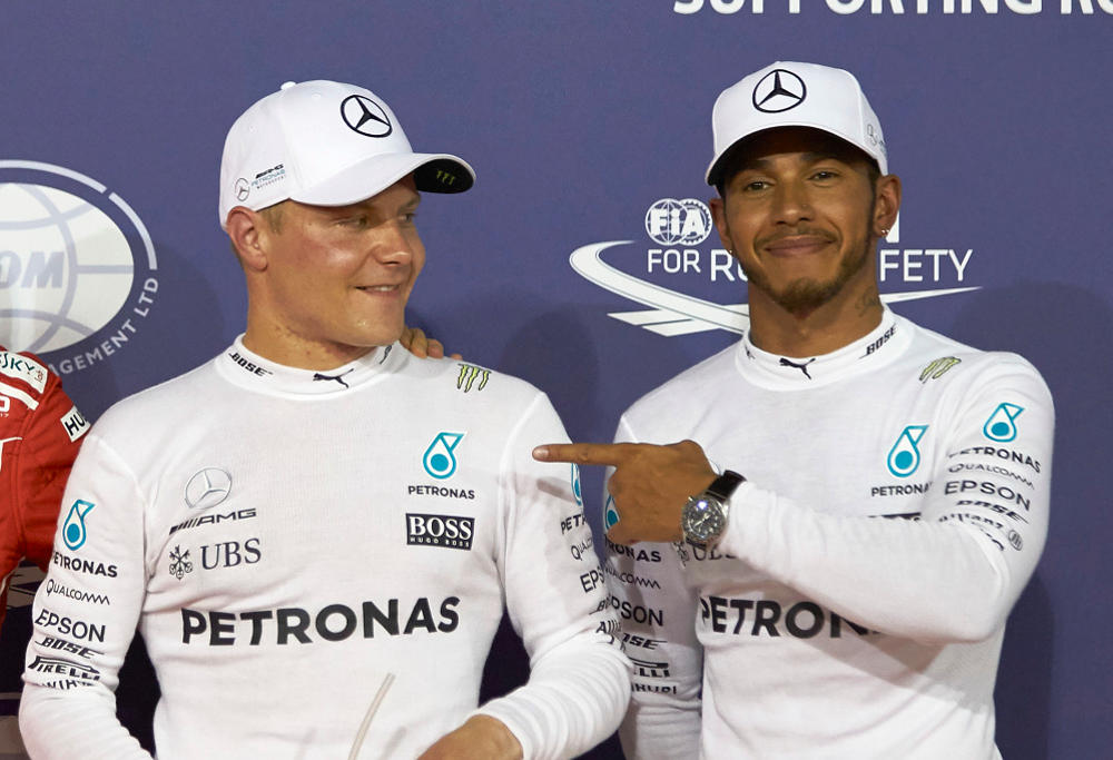 Mercedes teammates Valtteri Bottas and Lewis Hamilton share a moment on stage at a Formula One event.
