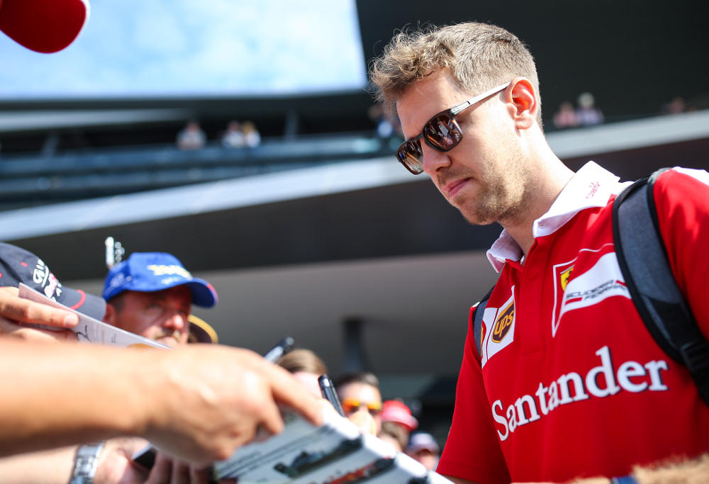 Sebastian Vettel signs autographs for Ferrari fans at the Formula One Grand Prix in Austria.