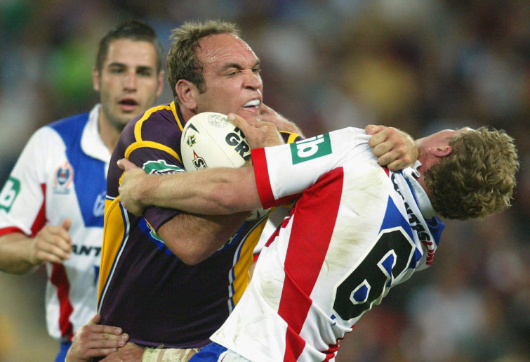 Gorden Tallis of the Broncos fends off the tackle of Steven Witt of the Knights