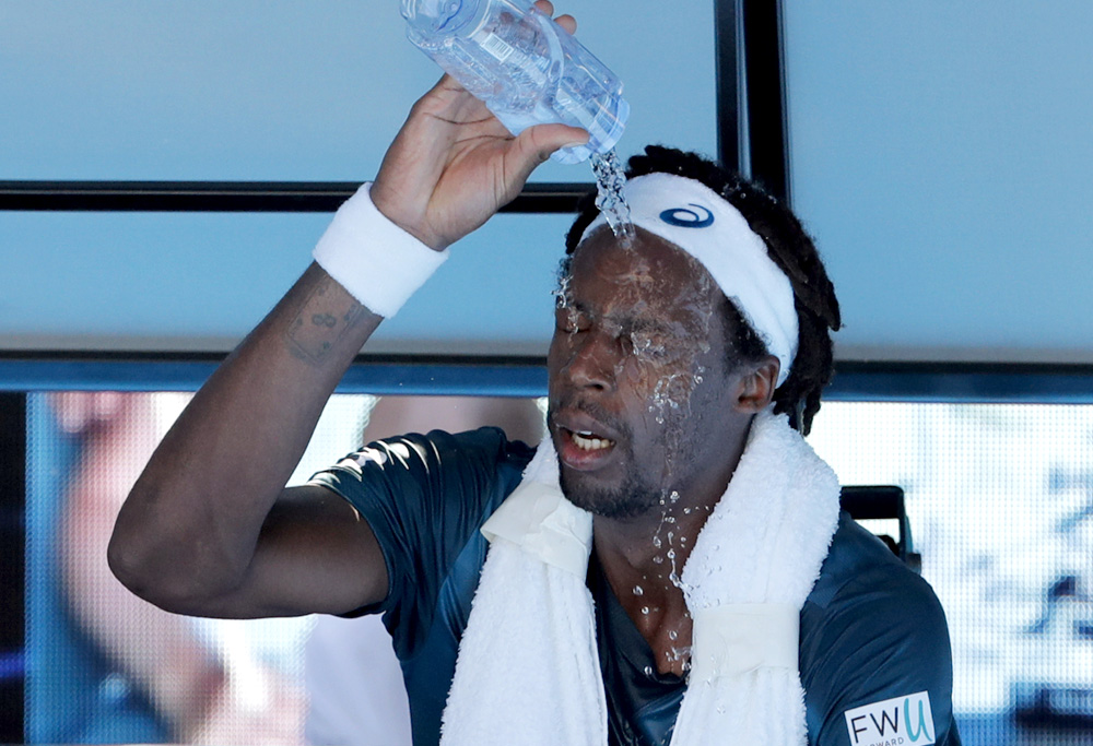 Gael Monfils douses himself in water at the 2017 Australian Open.