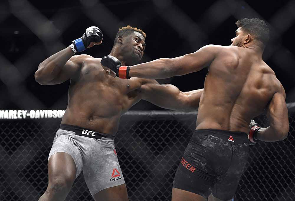 Francis Ngannou, left, hits Alistair Overeem in the first round during a UFC 218 heavyweight mixed martial arts bout, in Detroit.