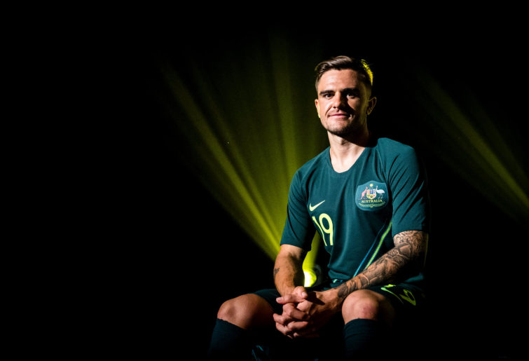 Josh Risdon shows off the Socceroos jerseys ahead of the 2018 World Cup