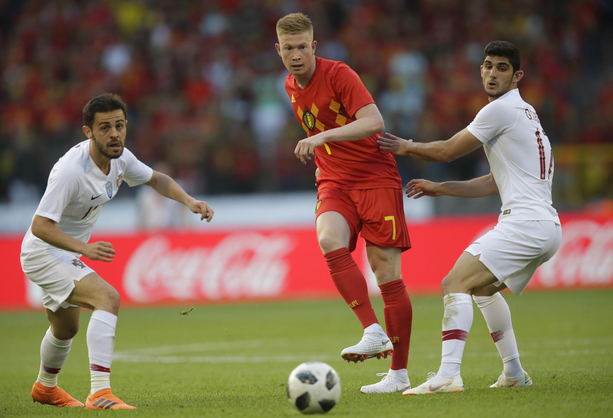 Kevin de Bruyne kicks the ball through the Portugal defence.