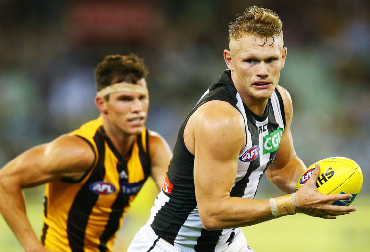 Adam Treloar of the Magpies runs with the ball