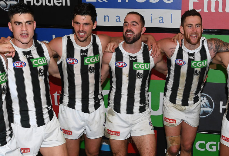 Collingwood Magpies players sing the team song after a victory