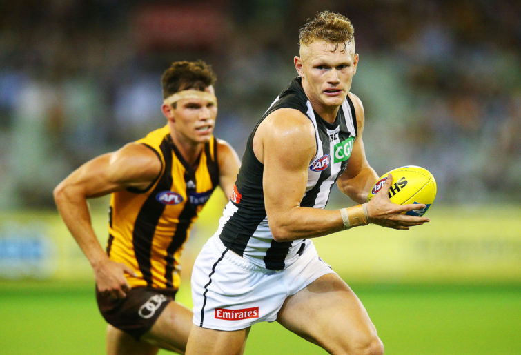 Adam Treloar of the Magpies runs with the ball during the round one AFL match between the Hawthorn Hawks and the Collingwood Magpies at Melbourne Cricket Ground.