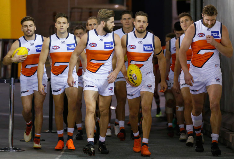 GWS Giants players run out of the tunnel.