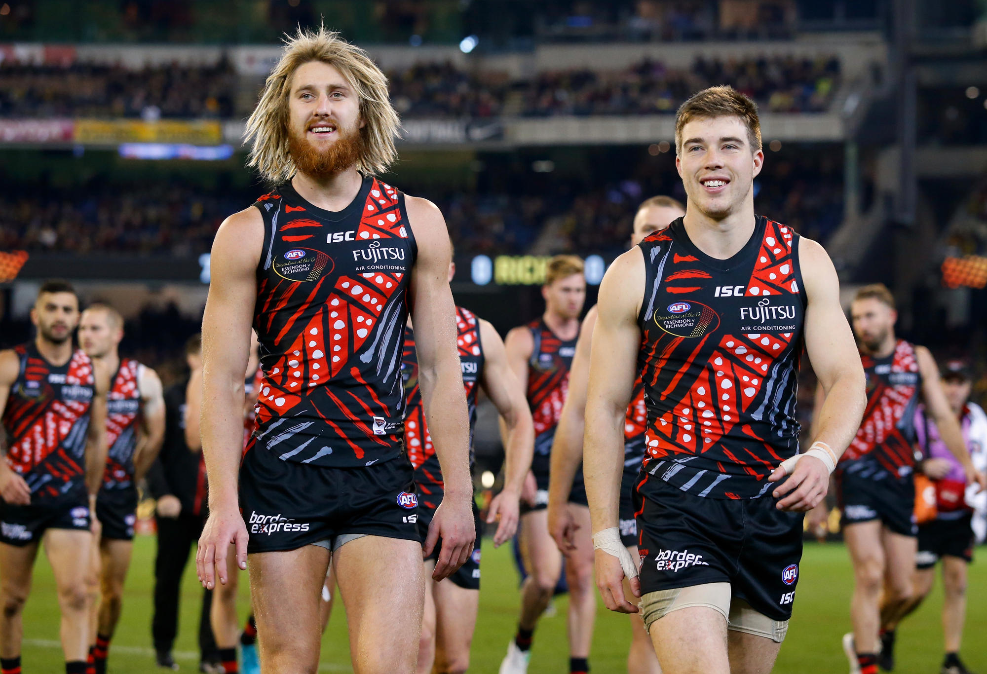 Dyson Heppell of the Bombers (left) walks to the war cry with Zach Merrett of the Bombers during the 2018 AFL round 11 Dreamtime at the G match between the Essendon Bombers and the Richmond Tigers at the Melbourne Cricket Ground on June 02, 2018 in Melbourne, Australia.
