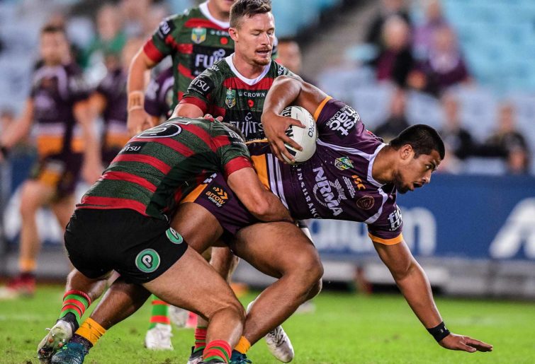 Payne Haas (right) of the Broncos is tackled by Robert Jennings of the Rabbitohs