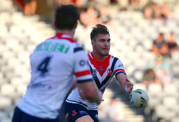 Angus Crichton passes the ball for the Roosters