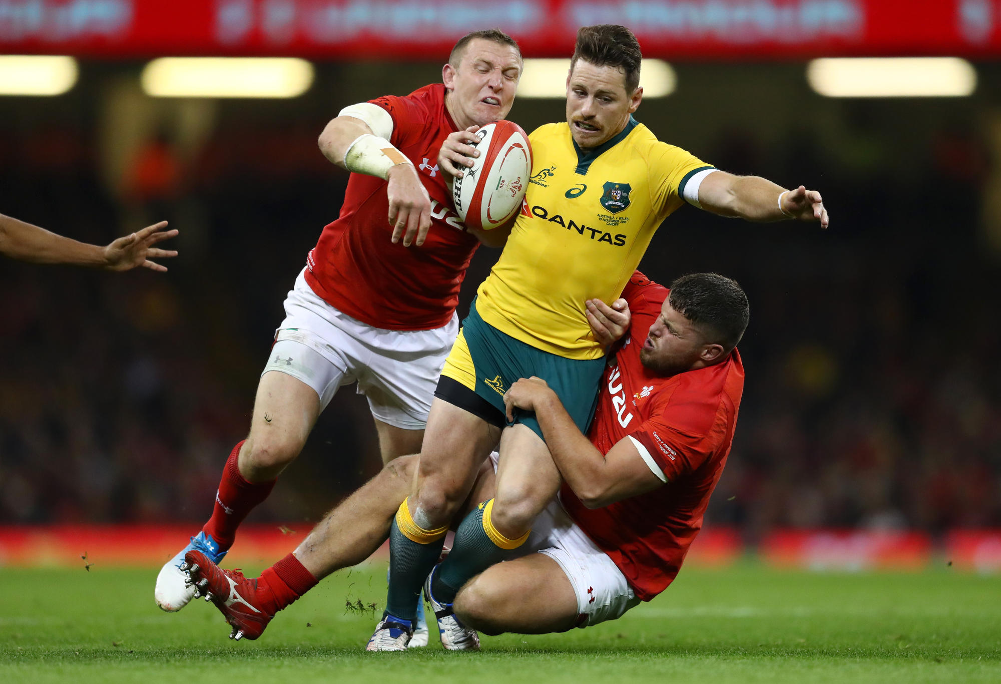 Bernard Foley of Australia is tackled by Hadleigh Parkes of Wales