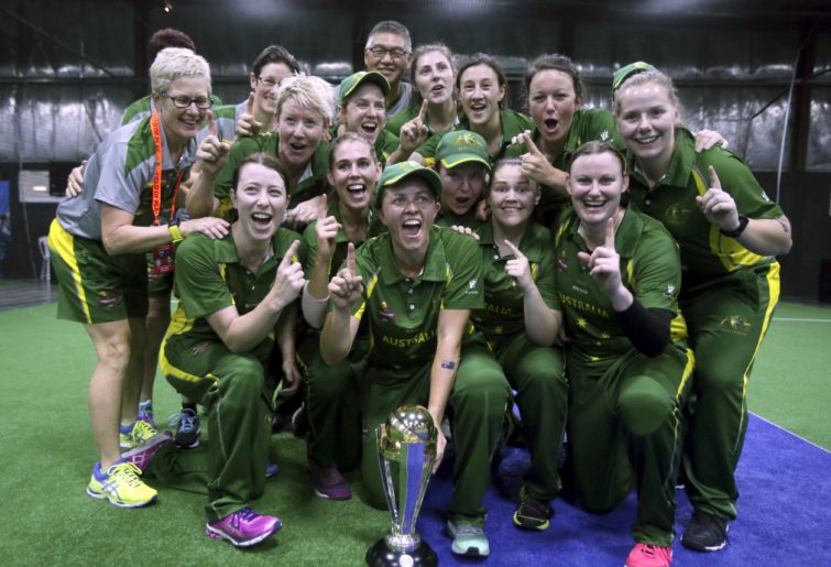 The Australian women's indoor cricket team celebrates with the World Cup trophy.