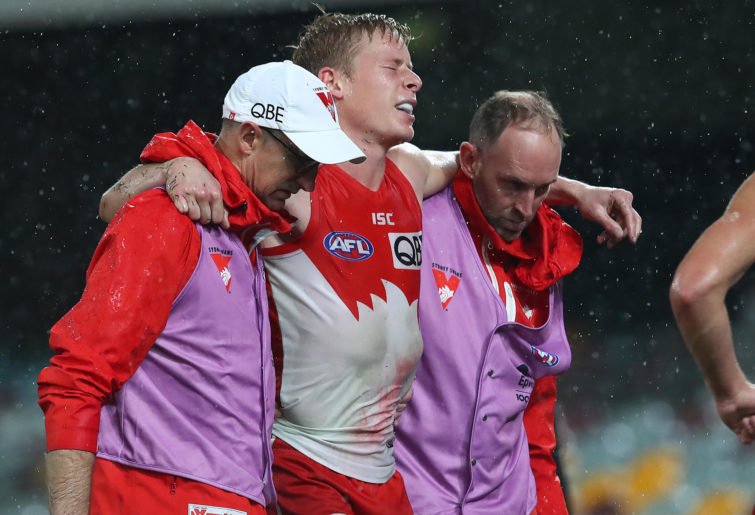 Isaac Heeney of the Swans is carried off injured