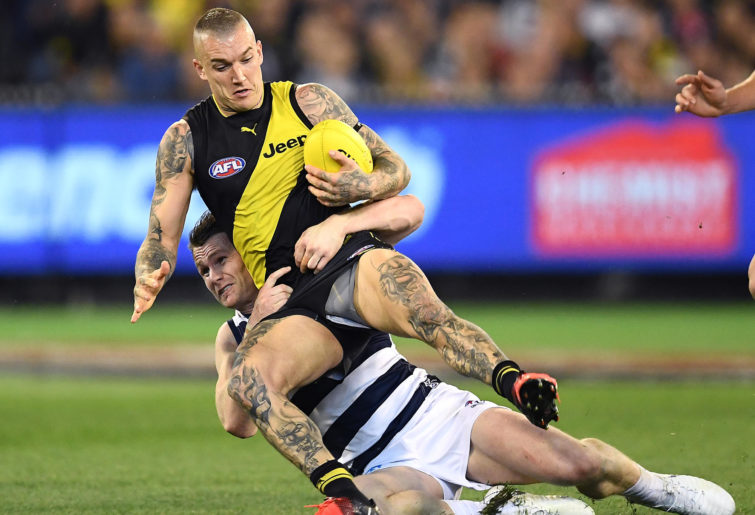 Dustin Martin of the Tigers is tackled by Patrick Dangerfield of the Cats