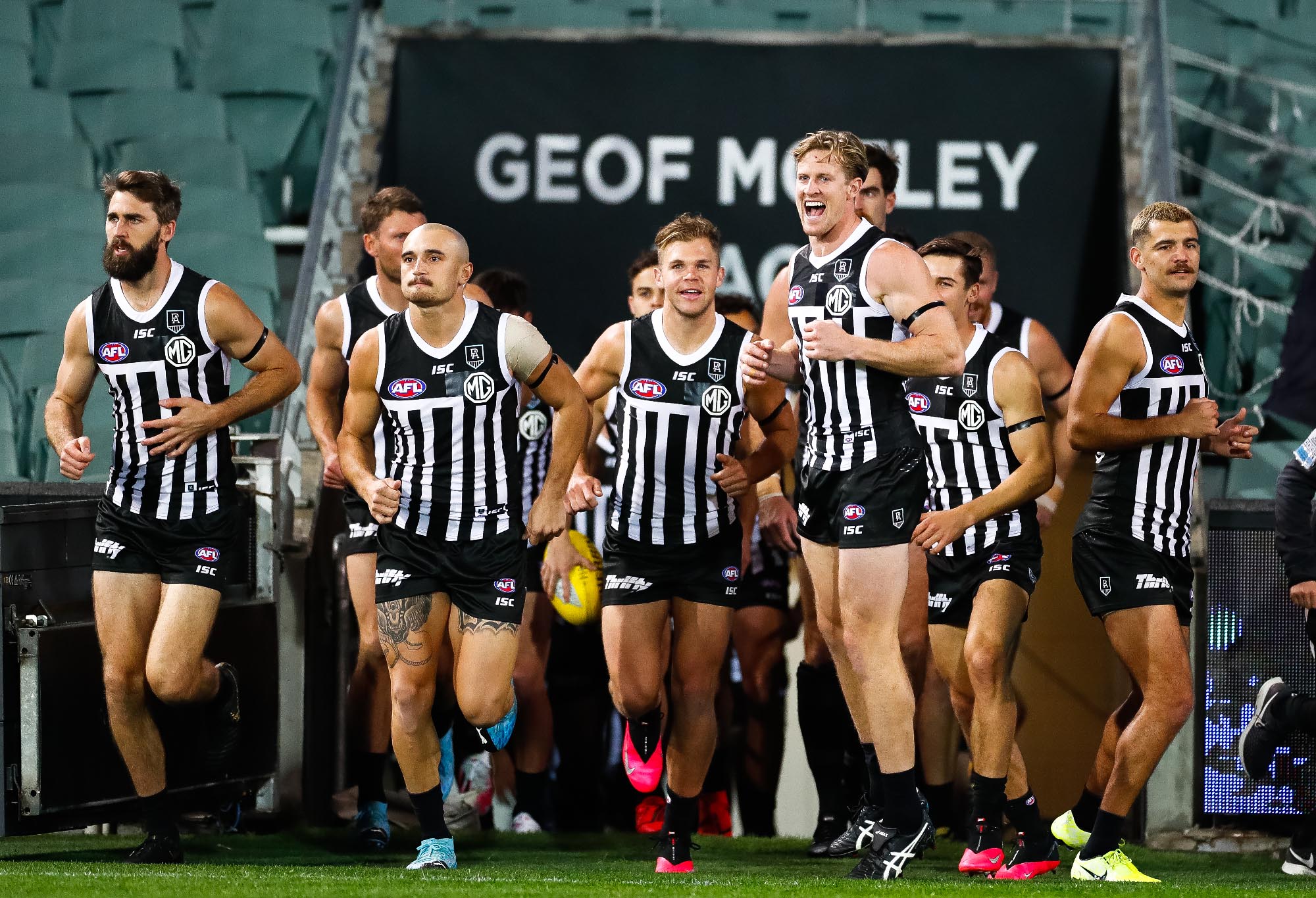 Port Adelaide run onto the field in their prison bar jersey