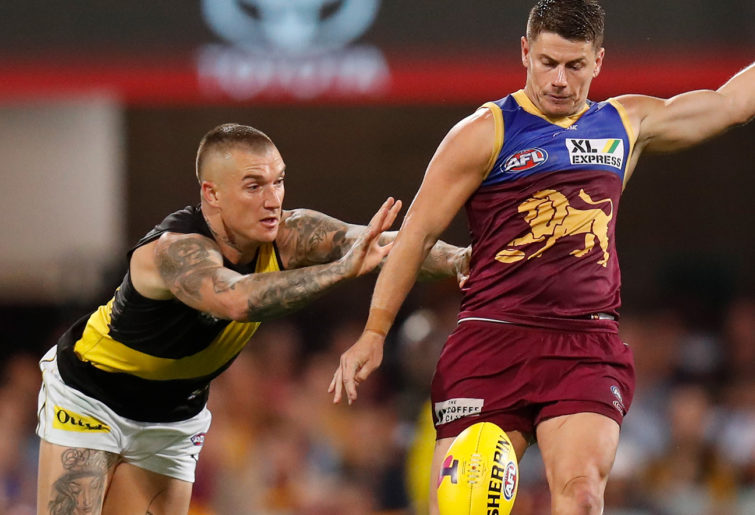 Dayne Zorko of the Lions is tackled by Dustin Martin of the Tigers