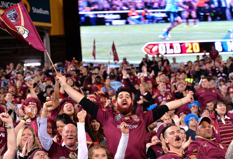 A Queensland fan celebrates during game three