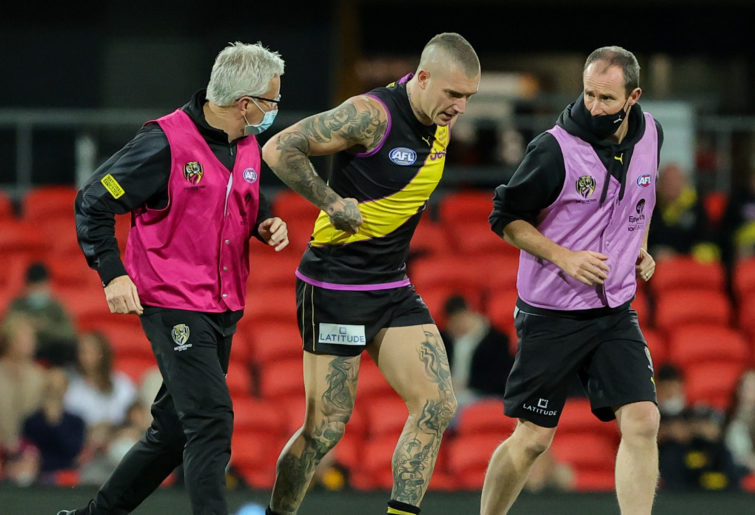 Dustin Martin is helped off the ground.