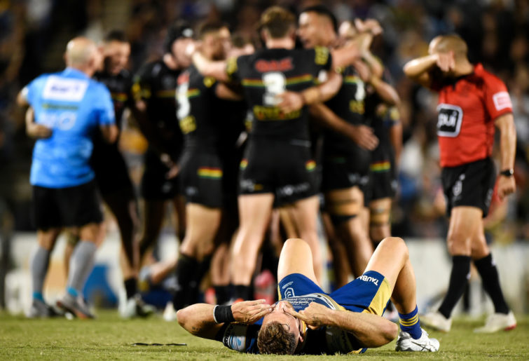 Bryce Cartwright of the Eels looks dejected after defeat as the Panthers celebrate victory.