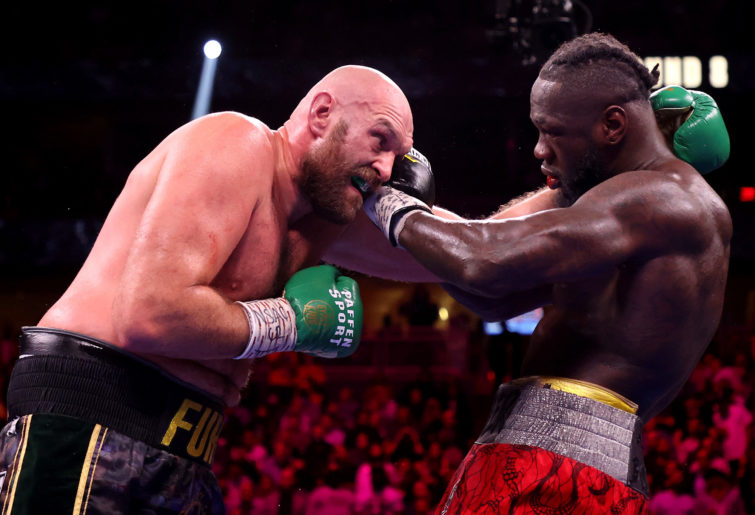 Tyson Fury and Deontay Wilder exchange punches.