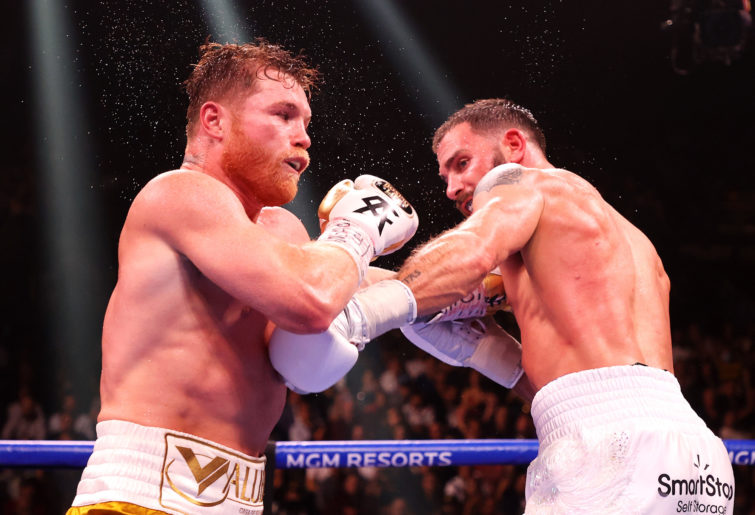 Canelo Alvarez and Caleb Plant exchange punches during their championship bout.