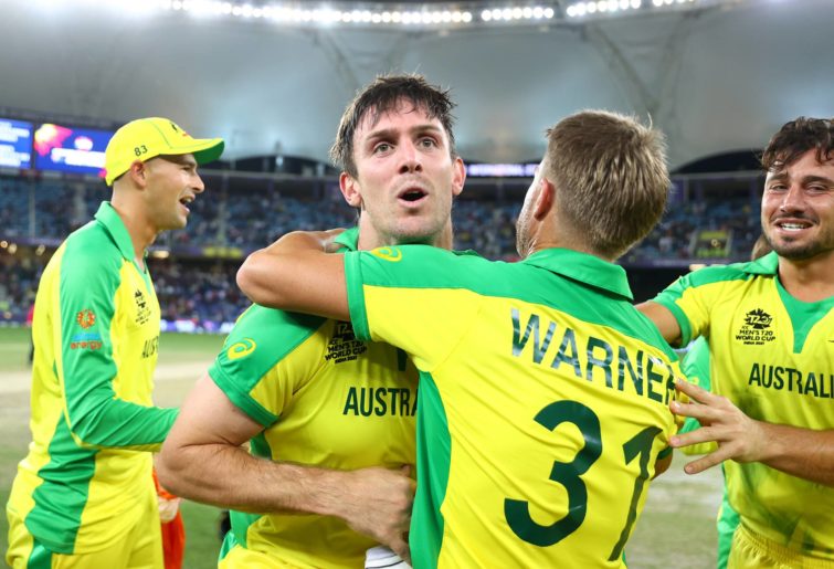 Australia's David Warner and Marcus Stoinis celebrate with Mitchell Marsh following their side's victory during the ICC Men's T20 World Cup final match between New Zealand and Australia at Dubai International Stadium on November 14, 2021 in Dubai, United Arab Emirates. (Photo by Michael Steele-ICC/ICC via Getty Images)