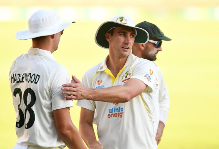 Australia captain Pat Cummins pats team mate Josh Hazlewood at the end of play during day three of the First Test Match in the Ashes series between Australia and England at The Gabba on December 10, 2021 in Brisbane, Australia. (Photo by Albert Perez - CA/Cricket Australia via Getty Images)