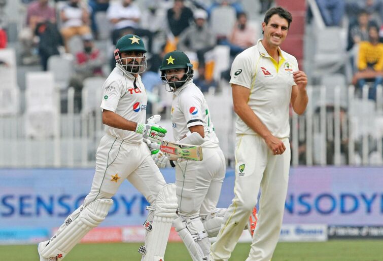 Babar Azam and Azhar Ali cross as Mitchell Starc looks on, Day 2 of the Pakistan v Australia Test at Rawalpindi.