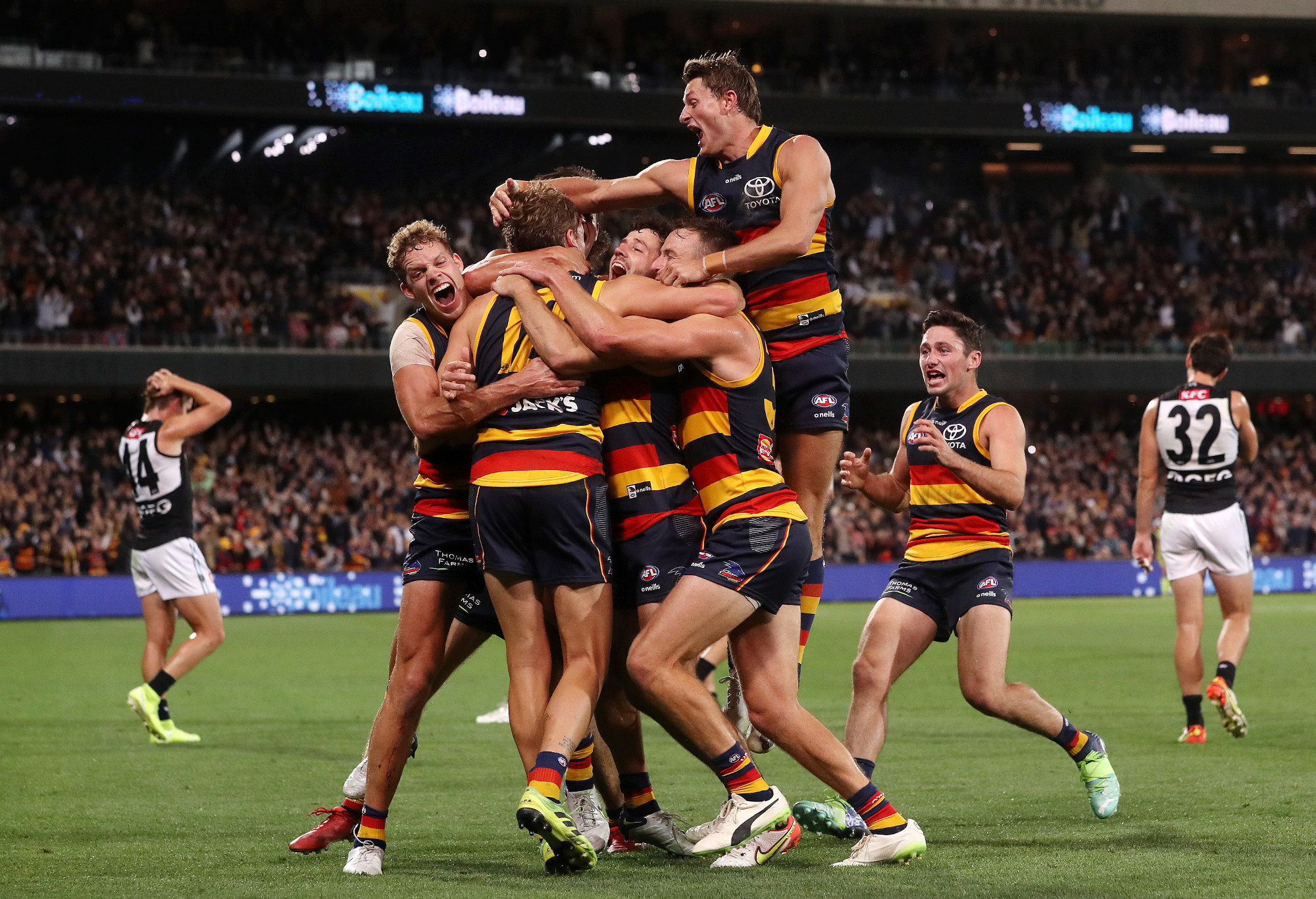 Players surround Jordan Dawson of the Crows after kicking the winning goal during Showdown 51.