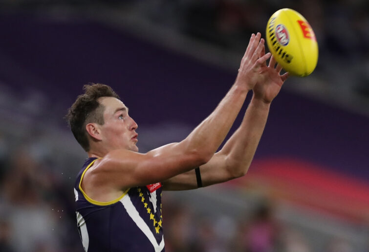 Brennan Cox of the Dockers marks the ball.