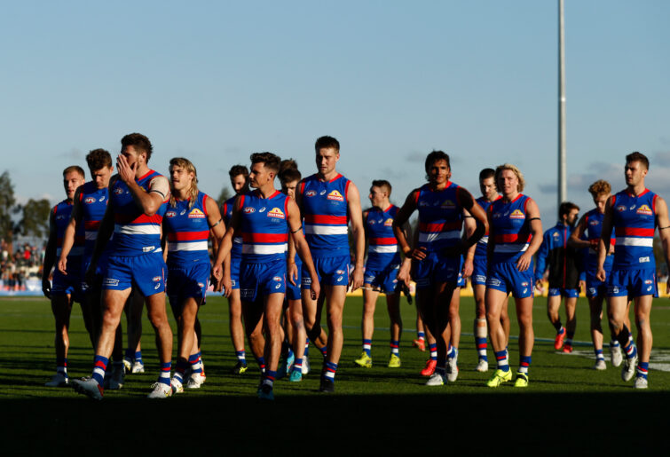 Dejected Western Bulldogs players walk from the ground after their loss to Adelaide.