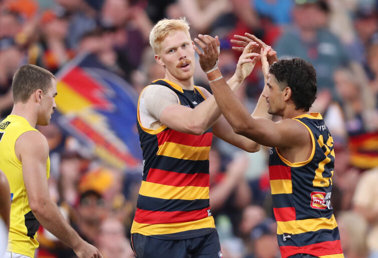 Elliott Himmelberg of the Crows celebrates a goal with Shane McAdam.