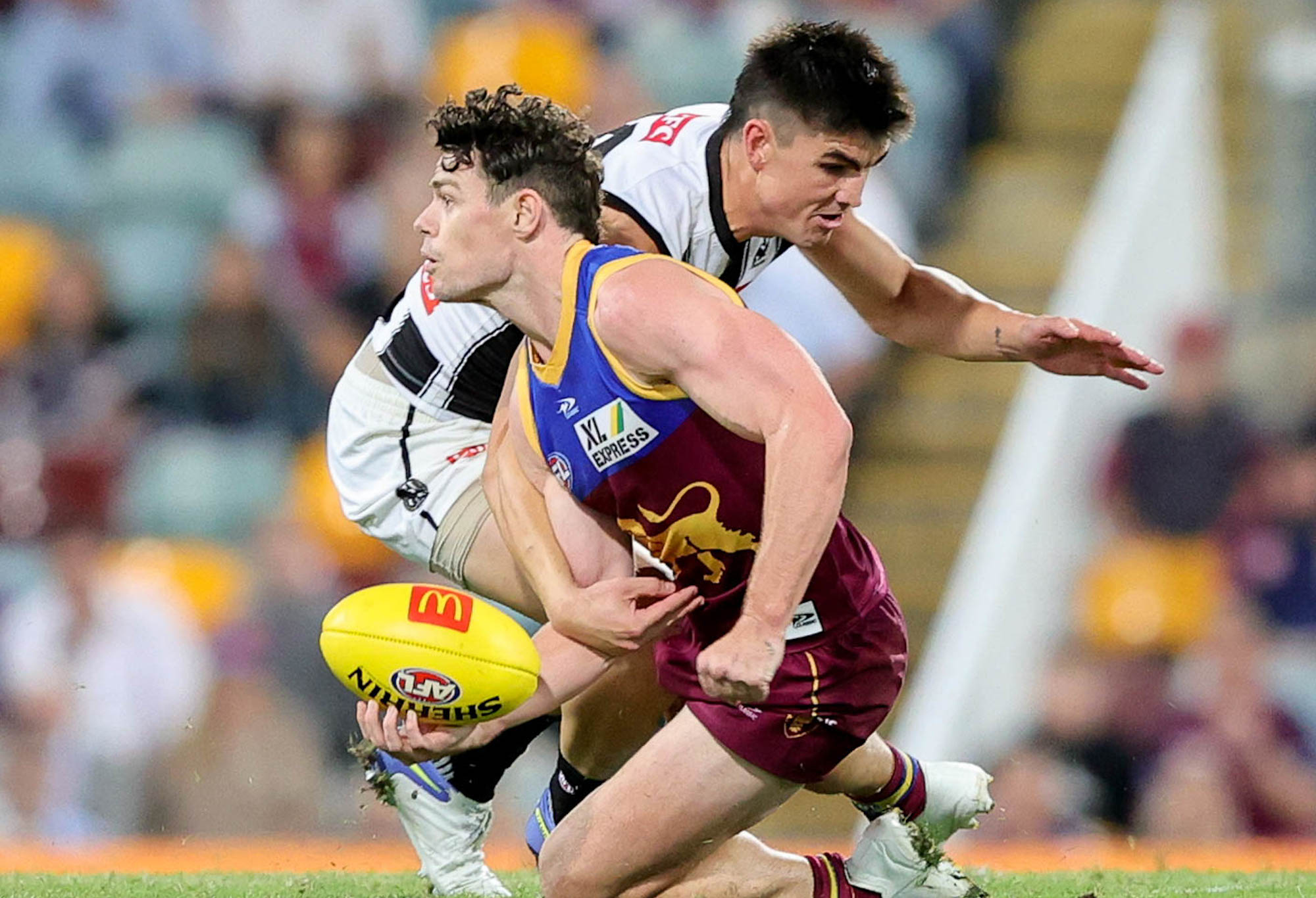 Lachie Neale of the Lions handpasses the ball.