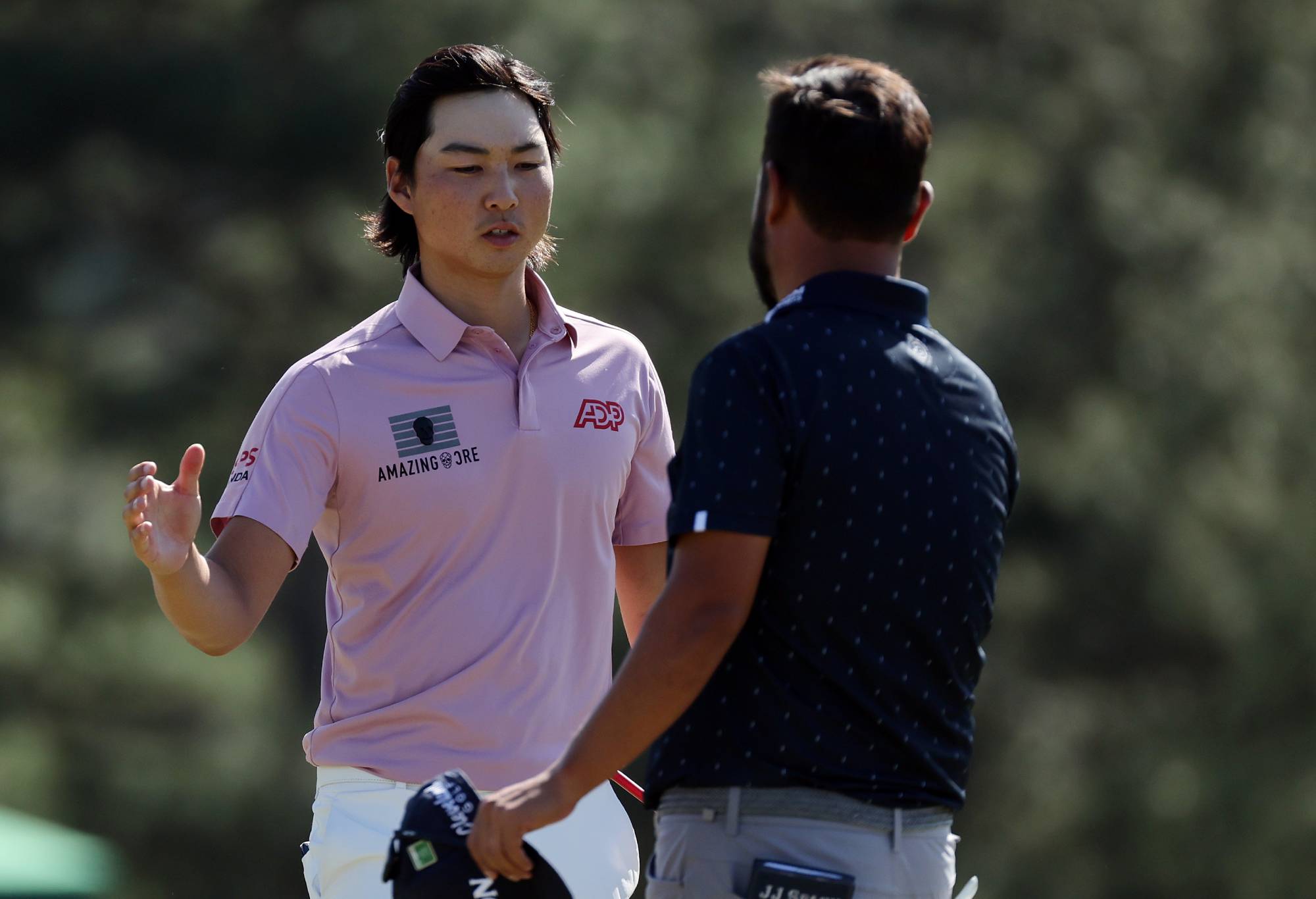Min Woo Lee of Australia (L) and J.J. Spaun shake hands on the 18th green after finishing their round during the final round of the Masters at Augusta National Golf Club on April 10, 2022 in Augusta, Georgia. (Photo by Gregory Shamus/Getty Images)