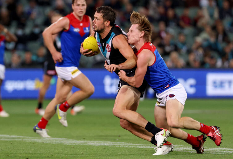 Travis Boak of the Power is tackled by Charlie Spargo of the Demons.