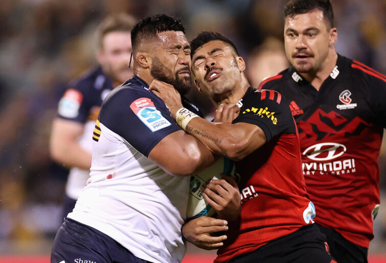 Folau Fainga'a of the Brumbies is tackled by Richie Mo'unga of the Crusaders.