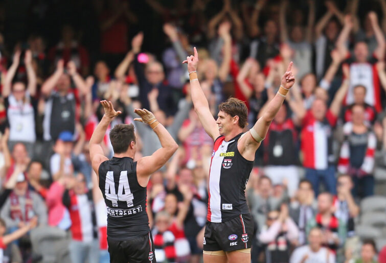 Justin Koschitzke of the Saints is congratulated by Stephen Milne during his final AFL game.