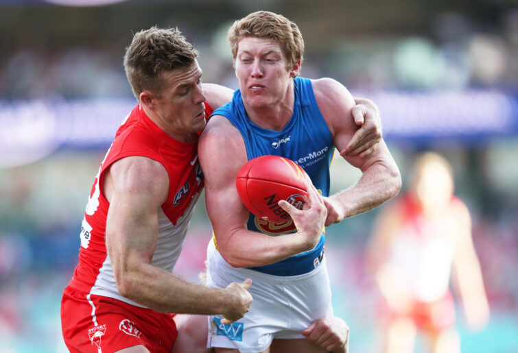 Matt Rowell of the Suns is tackled by Luke Parker of the Swans.