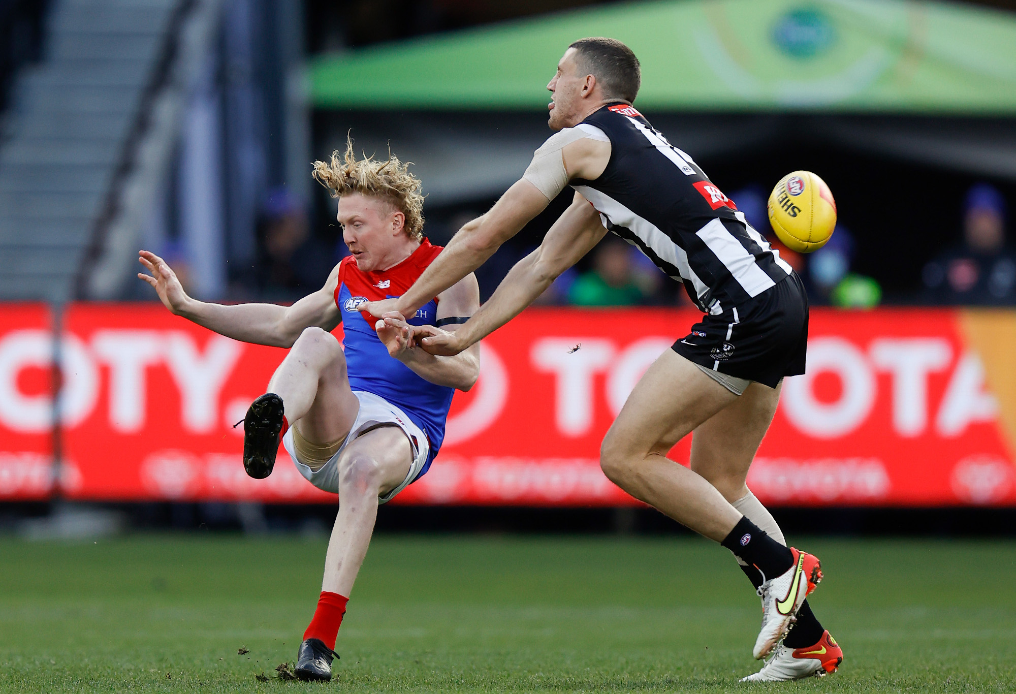 Clayton Oliver of the Demons and Darcy Cameron of the Magpies in action.