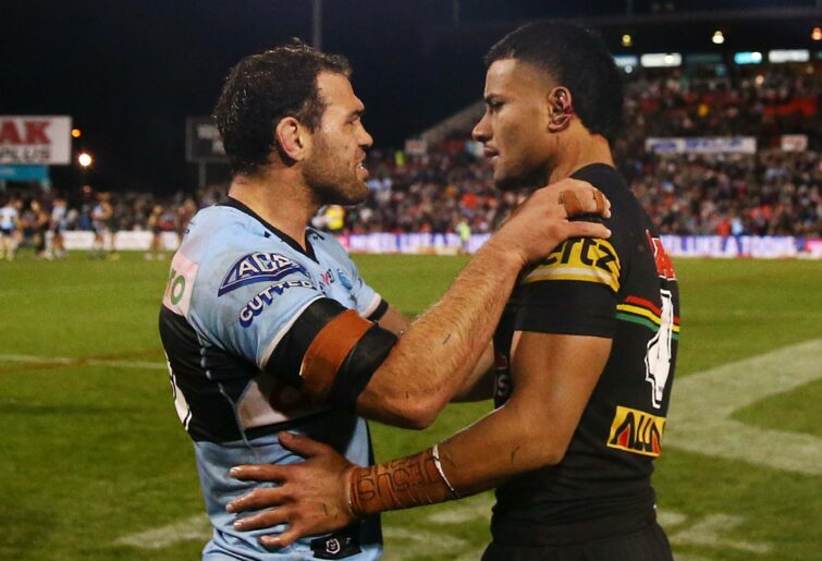 PENRITH, AUSTRALIA - July 23: Dale Finucane of Sharks leans on the ear of Stephen Crichton of Panthers after the