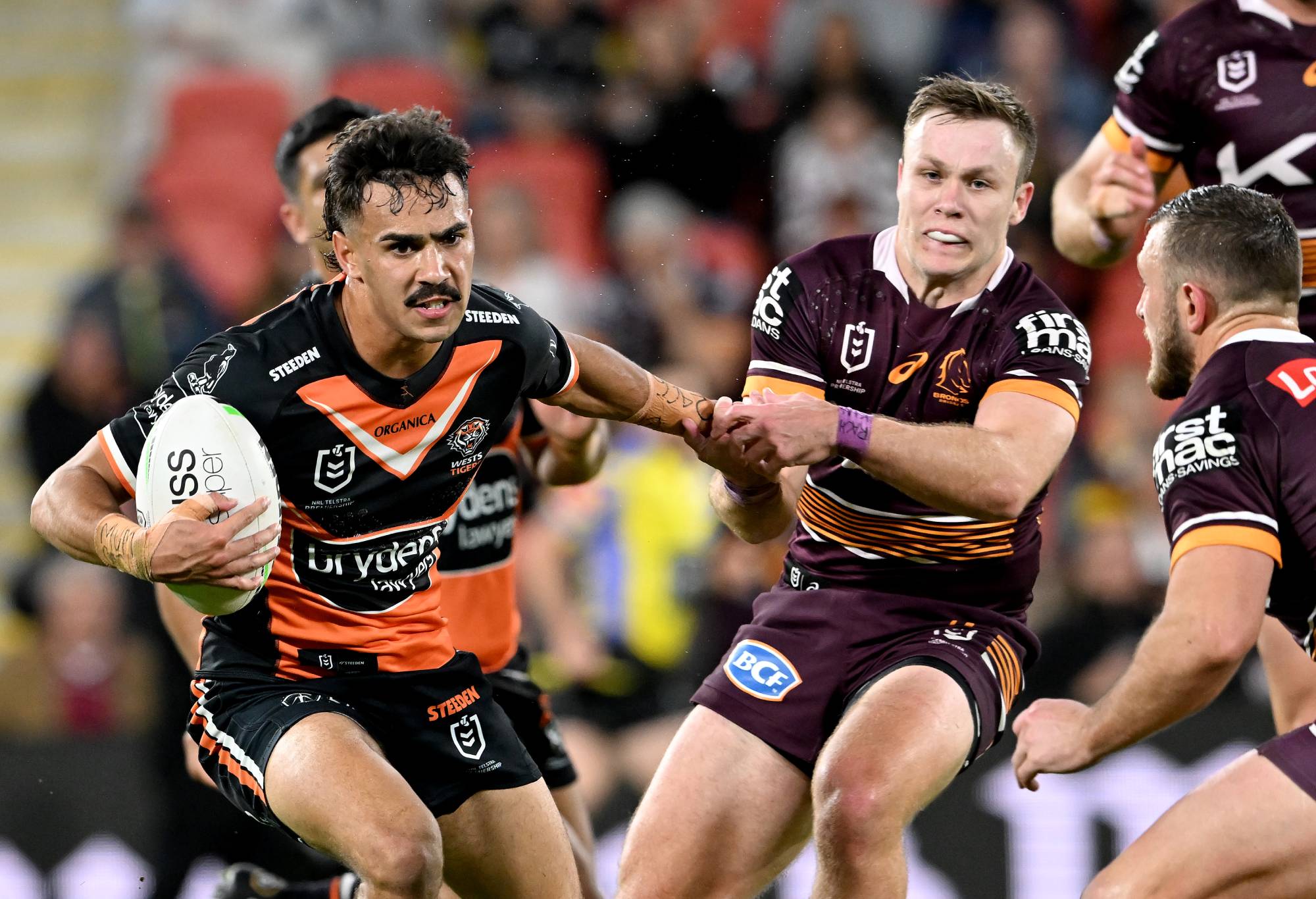 BRISBANE, AUSTRALIA - JULY 30: Daine Laurie of the Tigers attempts to break away from the defence during the round 20 NRL match between the Brisbane Broncos and the Wests Tigers at Suncorp Stadium, on July 30, 2022, in Brisbane, Australia. (Photo by Bradley Kanaris/Getty Images)