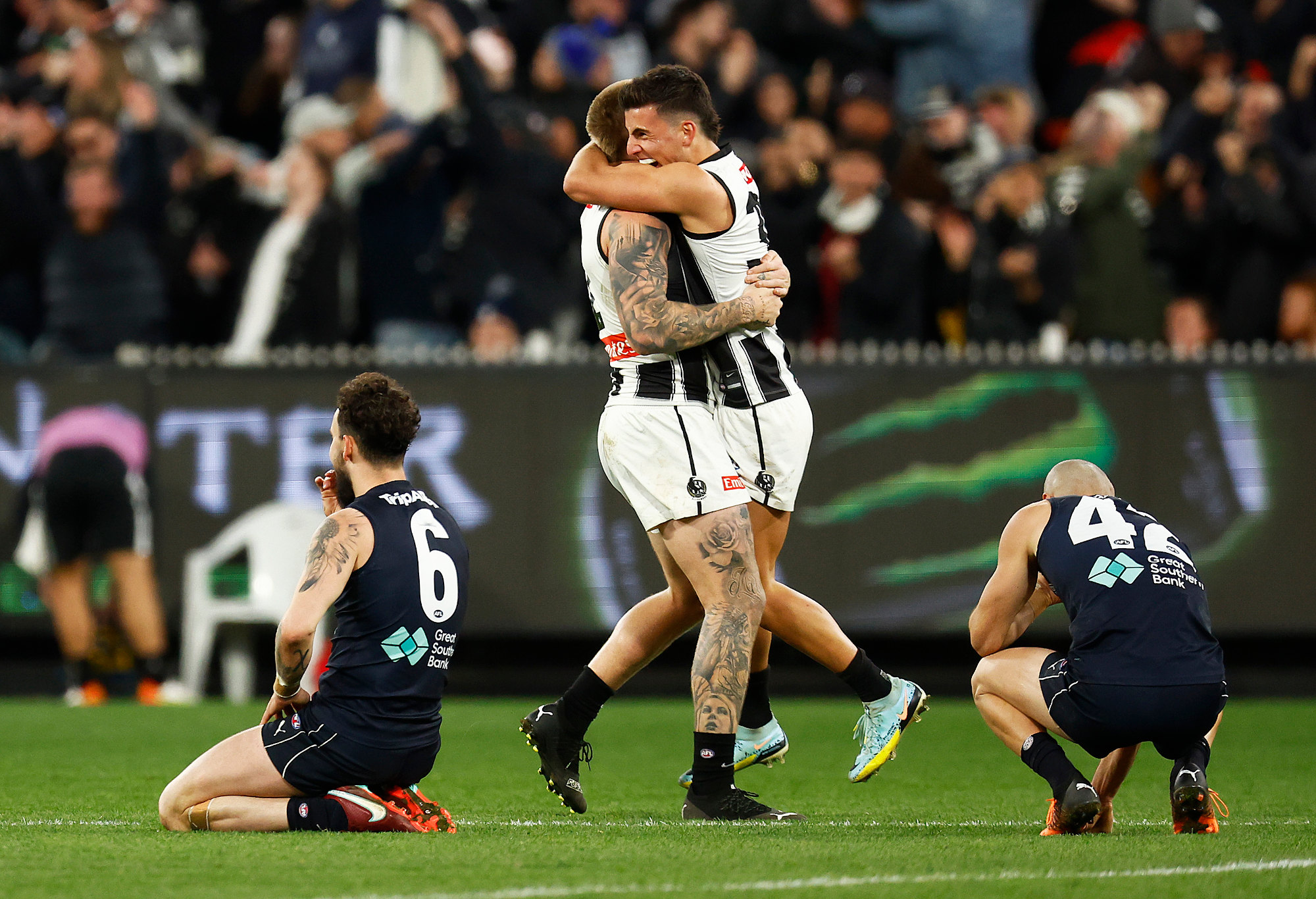 Zac Williams and Adam Saad of the Blues look dejected as Jordan De Goey and Nick Daicos of the Magpies celebrate.