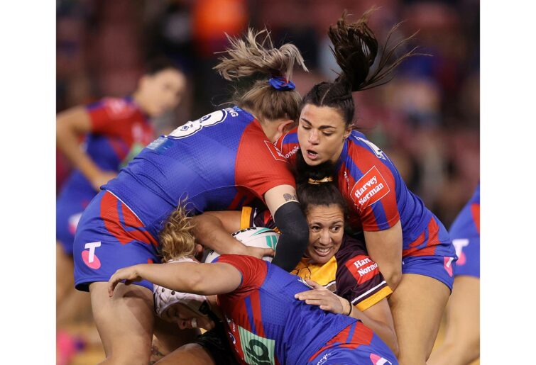 NEWCASTLE, AUSTRALIA - AUGUST 21: Tallisha Harden of the Broncos is tackled by Millie Boyle (R) and Caitlan Johnston of the Knights during the round one NRLW match between Newcastle Knights and Brisbane Broncos at McDonald Jones Stadium, on August 21, 2022, in Newcastle, Australia. (Photo by Cameron Spencer/Getty Images)
