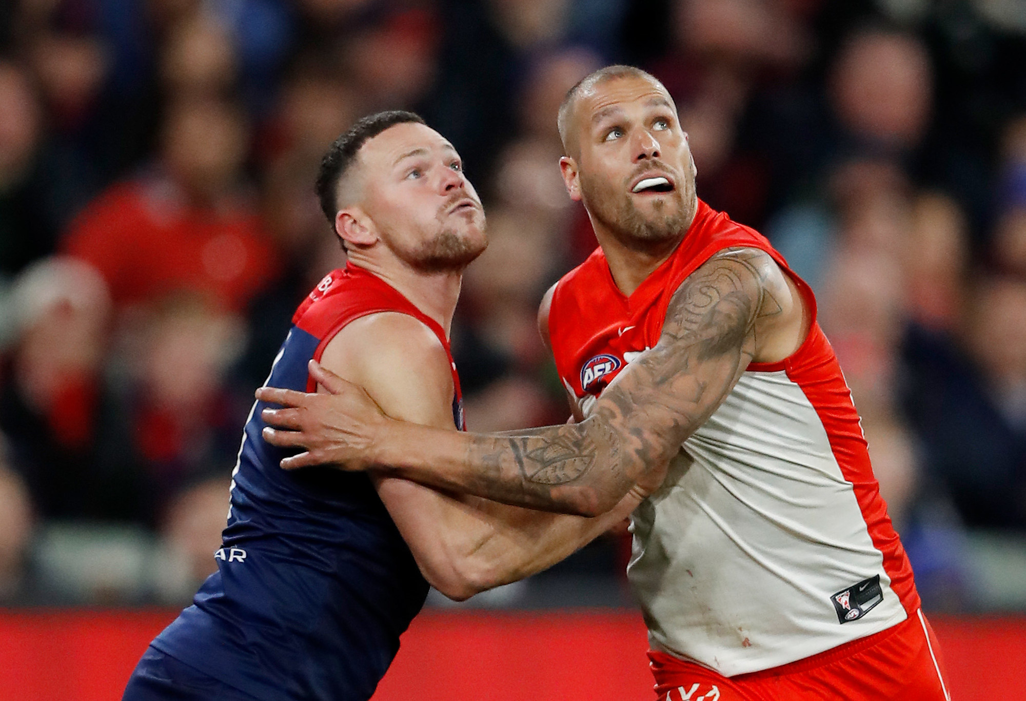 Steven May of the Demons and Lance Franklin of the Swans compete for the ball.