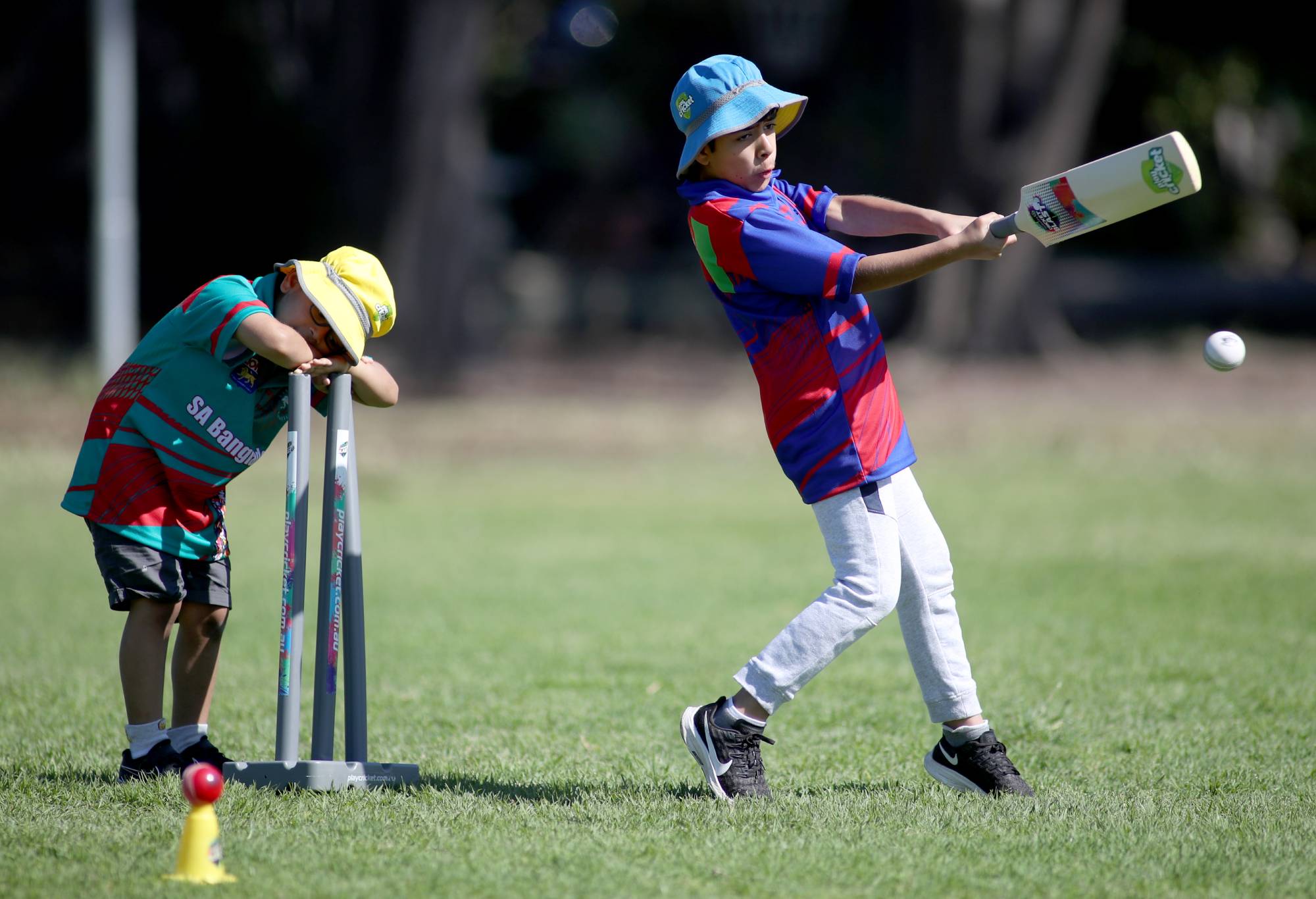 ADELAIDE, AUSTRALIA - OCTOBER 11:  A young boy from the Bangladesh team rests his head as an Afghanistan team member hits the ball at theSouth Australian Cricket Association Junior World Cup at the Fitzroy Cricket Club on October 11, 2020 in Adelaide, Australia. (Photo by Kelly Barnes/Getty Images)